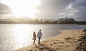 Couple enjoying a walk along Ettalong Beach at sunset