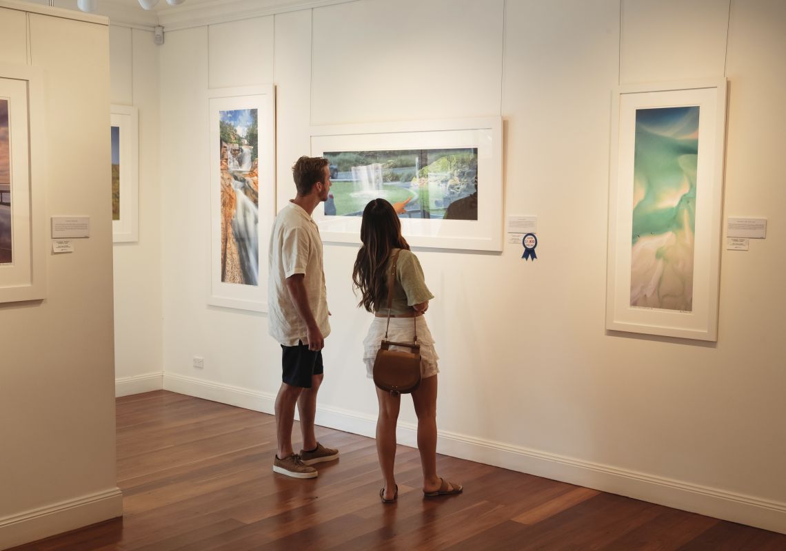 Couple viewing framed photographs at the Ken Duncan Gallery, Erina Heights