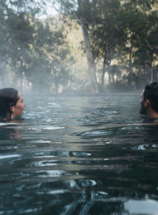 Couple enjoying a dip in the natural thermal springs in the Yarrongobilly area, Kosciuszko National Park