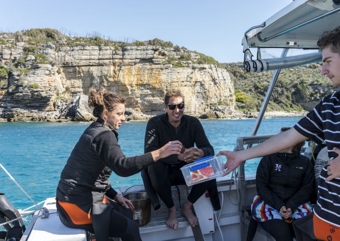 Dive master providing snacks for passengers on a Dive Jervis Bay tour