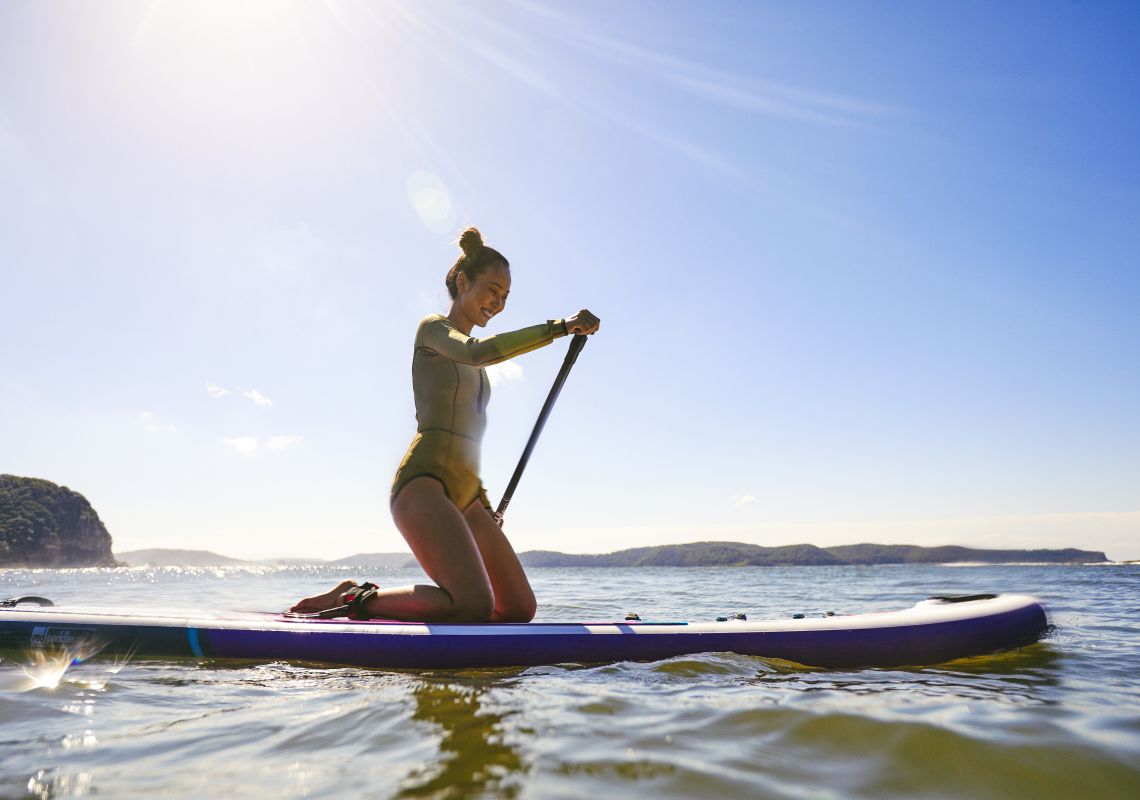 Woman enjoying a morning of stand up paddleboarding at Pearl Beach on the Central Coast
