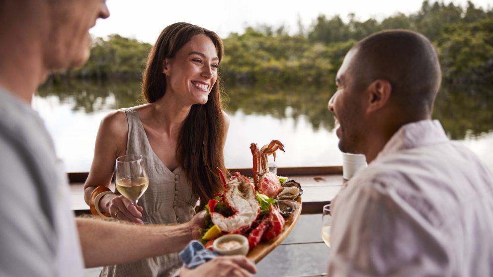 Couple enjoying food and drink with views across Brisbane Water at Woy Woy Fishermen's Wharf, Woy Woy